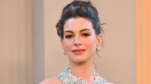 Anne Hathaway poses in a glittering gown and updo.